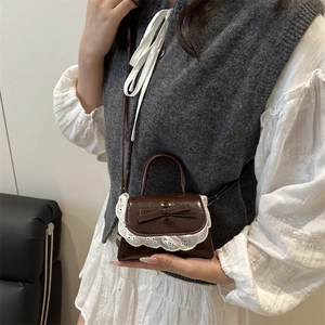 Mini borsa quadrata marrone con pizzo e fiocco indossata a tracolla dalla modella