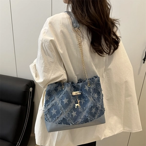 Sac fourre-tout en denim imprimé d'étoiles et bords effilochés porté par un mannequin