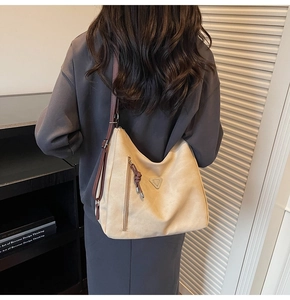 Détail du sac cabas en cuir beige avec logo triangle et poche zippée fonctionnelle