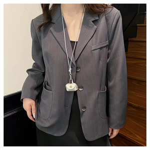 Miniature white handbag pendant necklace styled with an oversized grey blazer