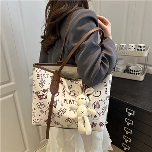 Sac fourre-tout en toile imprimée blanc cassé avec anses en cuir brun et lapin en peluche