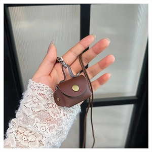 Close-up of a brown lychee pattern leather mini pouch with gold metal snap button and strap