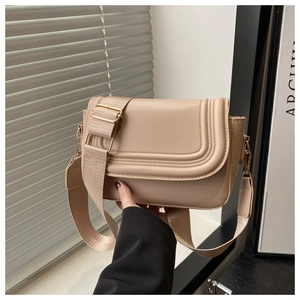 Dettaglio della borsa a sella beige con pelle PU liscia e tracolla larga in tessuto