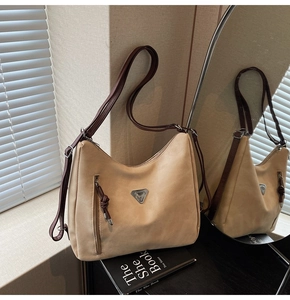 Détail du sac cabas en daim beige avec logo triangulaire et bandoulière marron