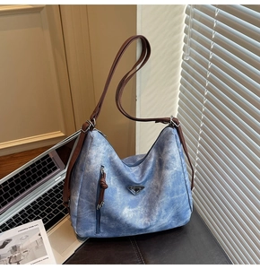 Détail du sac cabas bleu clair avec lanières marron et poche latérale à fermeture éclair