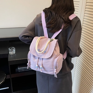 Minimalist lavender nylon backpack with braided handle and elegant cursive embroidery