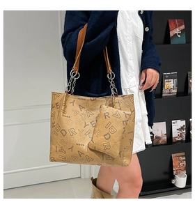 Detail of khaki tote bag with matching coin purse, brown straps and silver metal chain