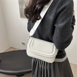 Elegante borsa a sella in pelle PU bianca con cuciture a U e tracolla larga su modella