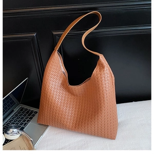 Close-up of woven leather texture on caramel brown hobo tote bag for daily use