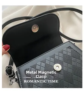 Dettaglio borsa a sella nera trapuntata con chiusura magnetica argento e trama in pelle PU