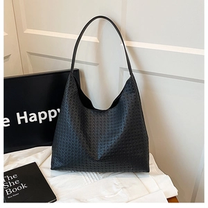 Detail of black woven hobo shoulder bag with textured weave and minimalist half-moon shape