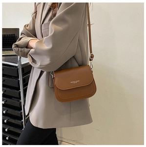 Borsa a sella marrone con stampa Fashion Trend indossata sopra un blazer beige
