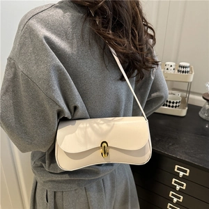 Retro minimalist cream underarm bag with gold clasp shown on model for elegant style
