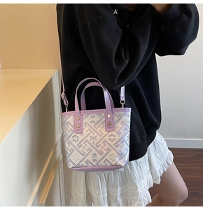 Close-up of light purple bucket bag with geometric embroidery and silver metal studs