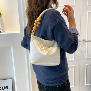Minimalist white satin underarm bag with elegant floral prints and wooden bead strap