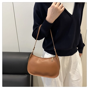 Detailed side view of a brown crescent shoulder bag with matte leather and metal zipper