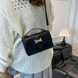 Chic black quilted crossbody bag with gold hardware and geometric textured finish