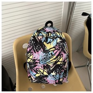 Detail of artistic graffiti backpack with colorful patterns on a beige chair