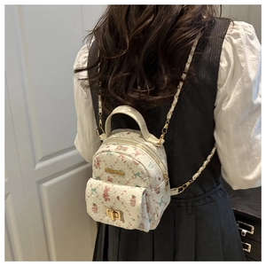 Detail of white pleated mini bag with bear floral print and golden metal turn-lock closure