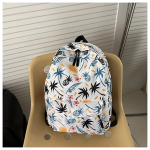Detail of white backpack featuring tropical palm and pineapple print with black zippers