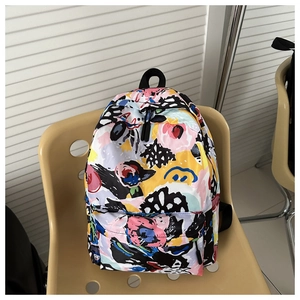 Detail of multi-color abstract floral backpack on a chair showing zipper and texture