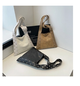 Détail de trois sacs à rivets en crème, marron et noir avec bandoulières à œillets
