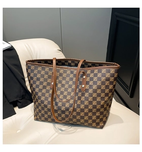Detail of checkered pattern texture and leather piping on the large shoulder tote bag