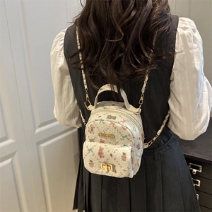 Chic off-white mini backpack with cute bear prints and chain straps worn by model