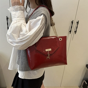 Chic red patent leather handbag with gold chain strap and deer charm detail
