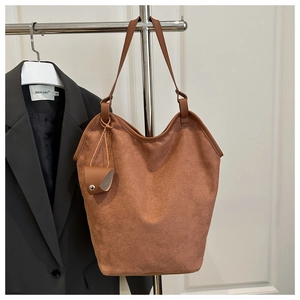 Détail d'un sac cabas en daim marron vintage avec une mini pochette assortie suspendue