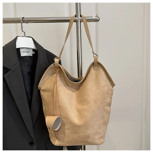 Détail d'un grand sac fourre-tout beige en suédine avec un pendentif décoratif