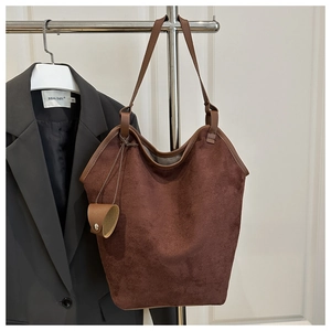 Détails de la texture en daim doux et bordure en cuir sur ce grand sac fourre-tout marron