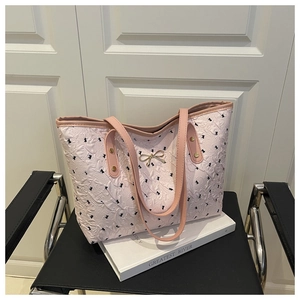 Detailed view of pink quilted tote bag with black bows and golden buckle hardware