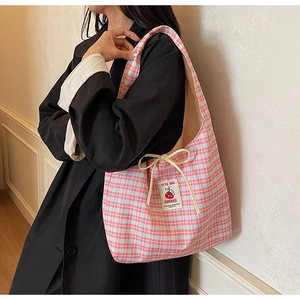 Dettaglio della borsa tote a scacchi rosa e blu con fiocco a coulisse e patch in tessuto