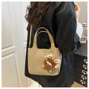 Sac seau beige en cuir texturé avec détail de charm monstre en peluche à ailes