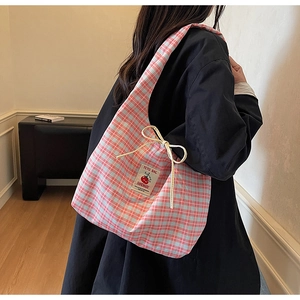 Dettaglio di una borsa in tela a scacchi rosa e blu con etichetta fatta a mano e coulisse