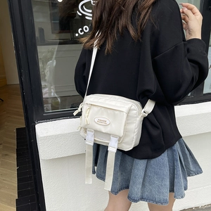 White nylon messenger bag with adjustable straps and front pockets for students