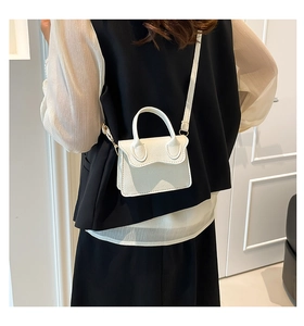 Détail du mini sac bandoulière blanc crème avec texture litchi et bordure ondulée