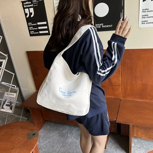 Minimalist white canvas tote bag with blue C'est La Vie print for women's daily commute