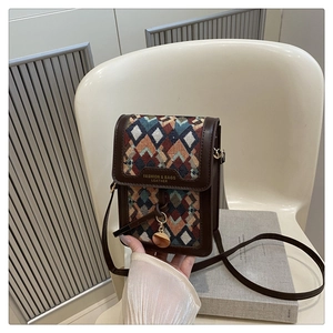 Detail of retro small square bag with geometric woven fabric and brown leather trim