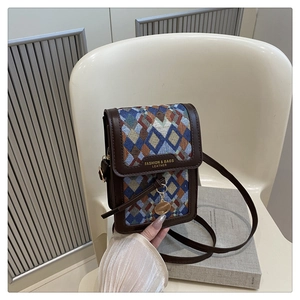 Detail of retro mini crossbody bag with colorful woven pattern and gold pendant