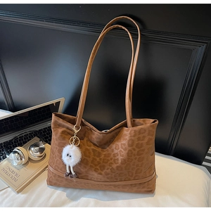 Dettaglio della borsa tote leopardata con ciondolo di peluche e sottili spalline