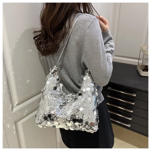 Detail shot of a silver sequin dumpling bag featuring reflective mirror disc textures