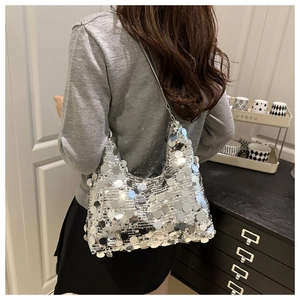 Detailed view of silver sequin shoulder bag showing large reflective round discs on fabric