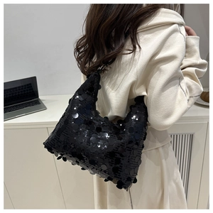 Detail of black sequined crescent bag showing the reflective texture and zipper design