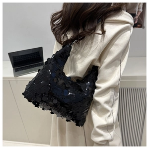 Detail of black sequined hobo shoulder bag showing shimmering circular textures and shape