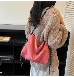 Pink nylon tote bag with polka dot rope strap shown as crossbody on model back