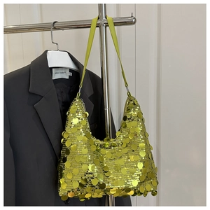 Detailed view of neon green sequin hobo bag on shoulder strap in a fashion styling context