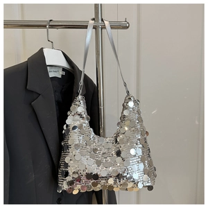 Detail of silver sequin hobo bag showing layered round discs and slim leather shoulder strap