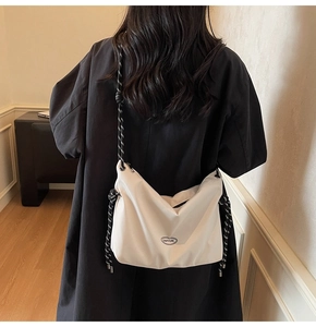 Detail of a large cream crossbody bag with woven rope strap and GAIFYUN logo